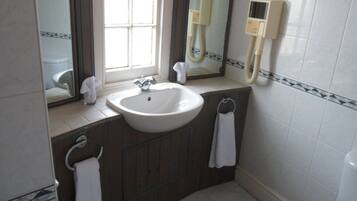 A bathroom with a white sink, a mirror, a towel rack, and a toilet.