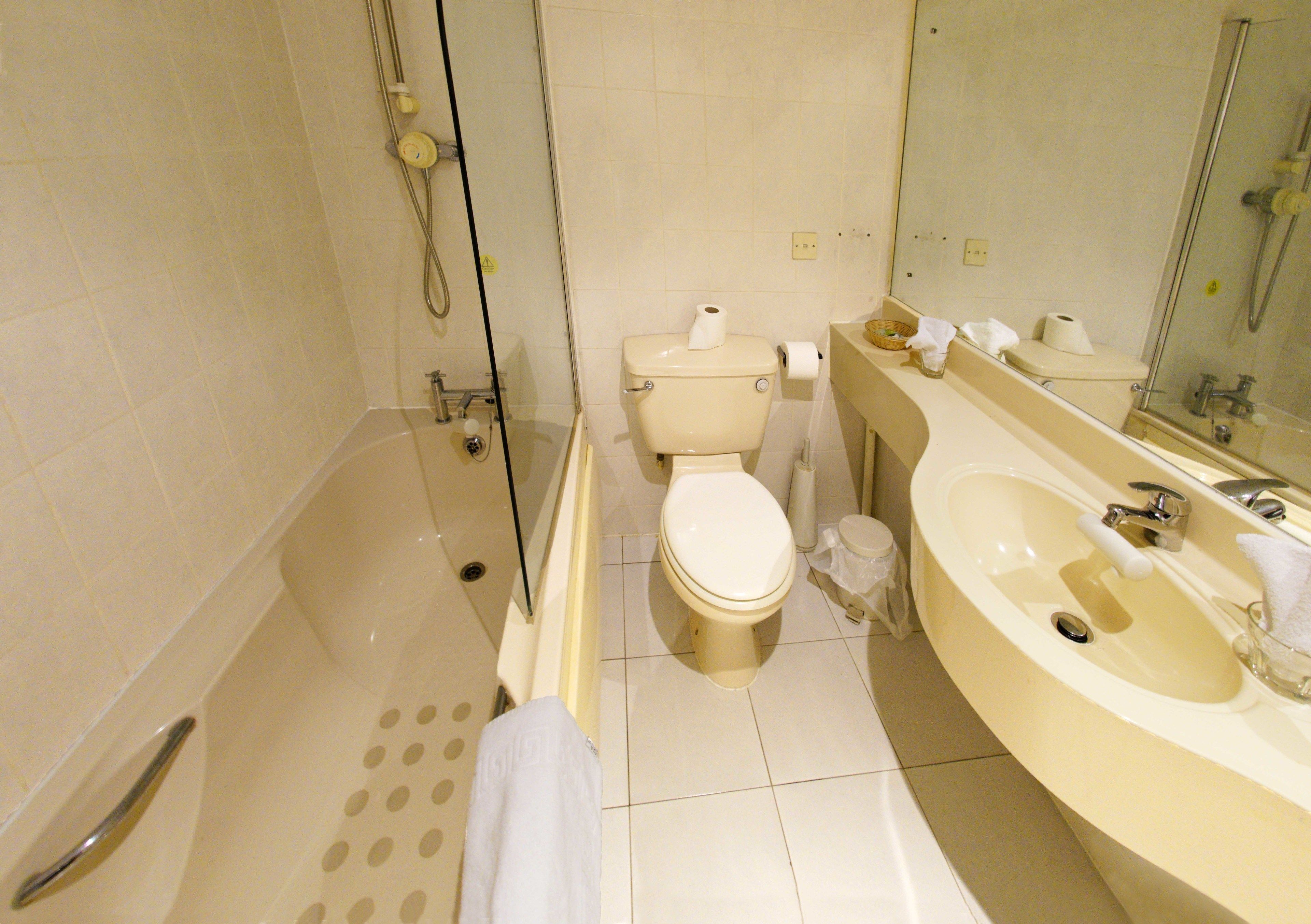 A bathroom with a bathtub, toilet, and sink.