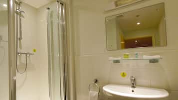 A bathroom with a glass-enclosed shower, a pedestal sink, and a mirror above the sink.