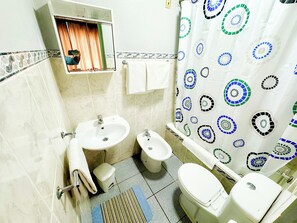 A bathroom with a sink, toilet, bidet, and a shower curtain with a circular pattern. - Residencial Monaco 38051-AL (Funchal)