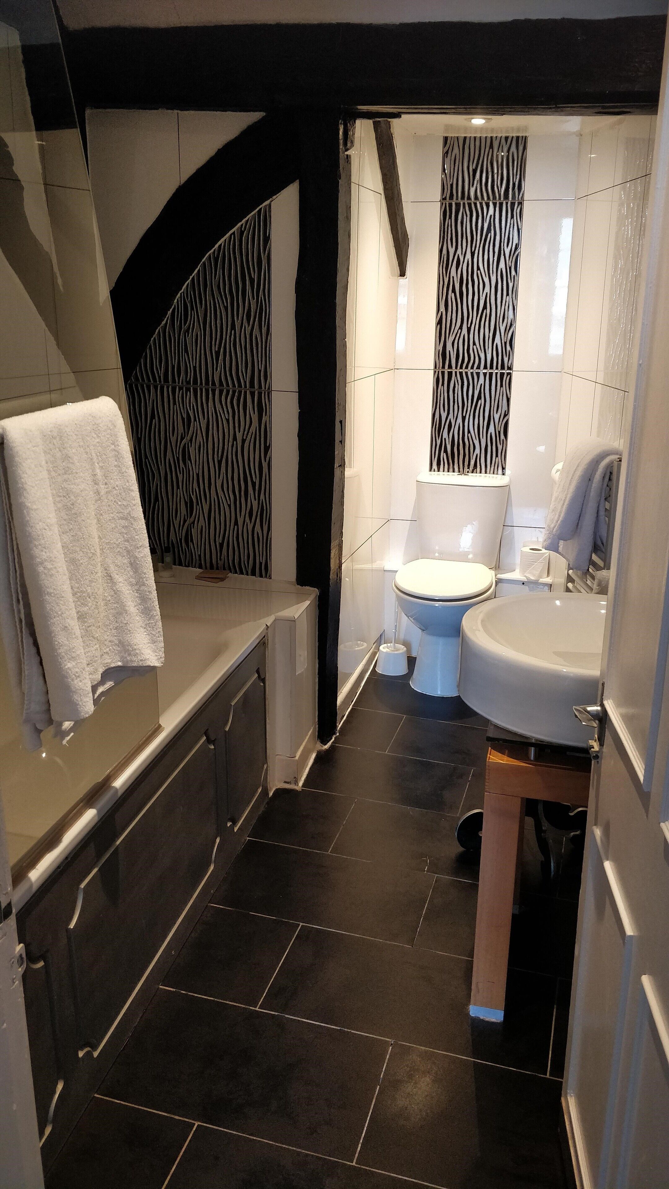 A modern bathroom with a bathtub, toilet, and sink.