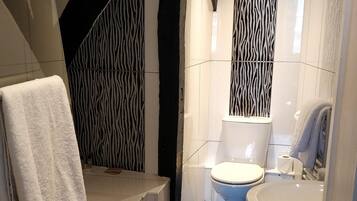A modern bathroom with a bathtub, toilet, and sink.