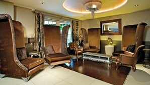 A luxurious living room with high-backed leather armchairs, a sofa, and a coffee table. - The Spread Eagle Hotel (Thame)
