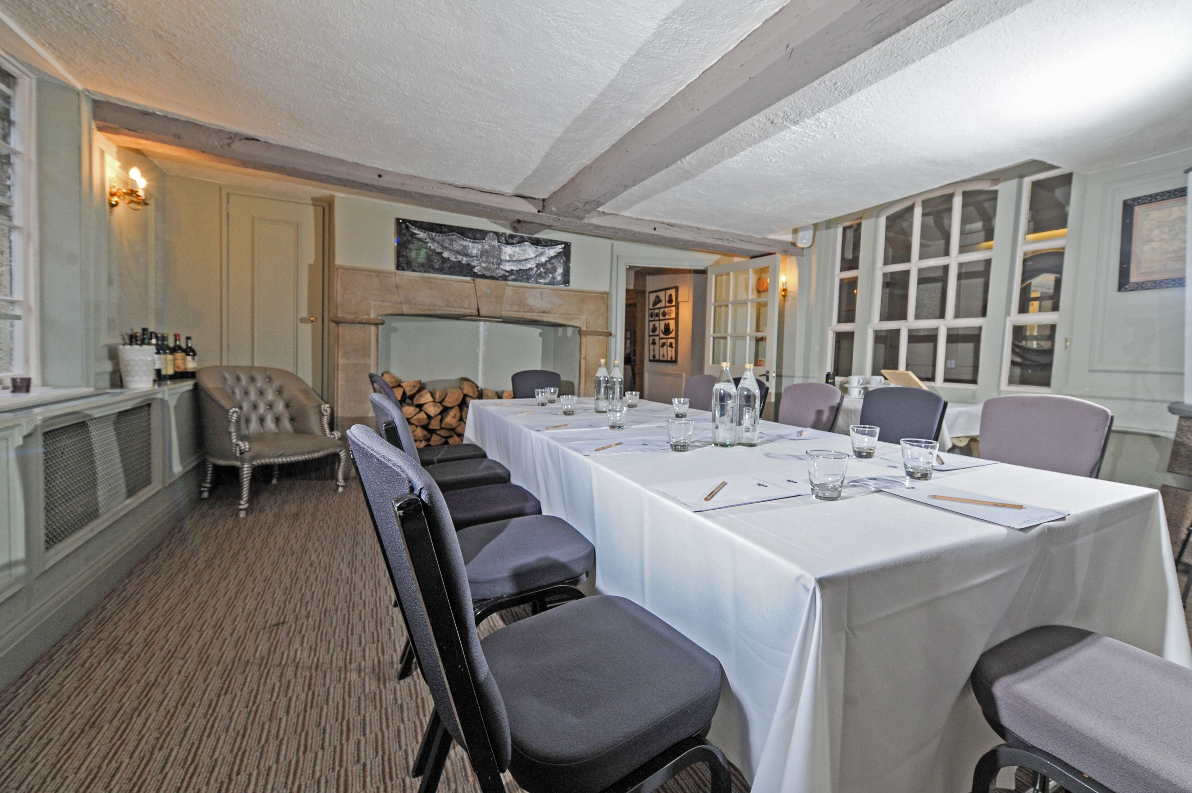 A conference room with a long table, chairs, and a fireplace.