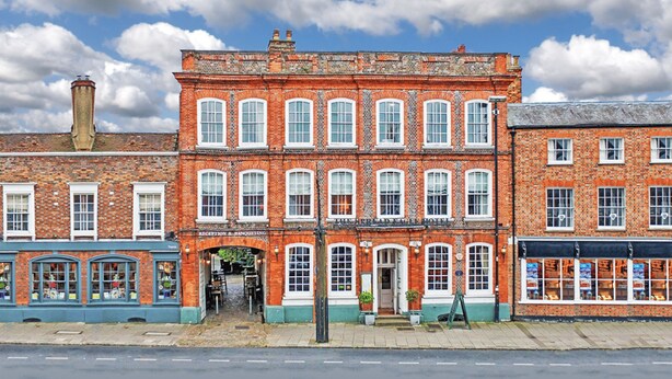A red brick building with multiple windows and a green awning. - The Spread Eagle Hotel (Thame)