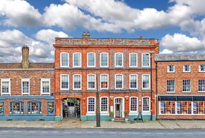 A red brick building with multiple windows and a green awning. - The Spread Eagle Hotel (Thame)