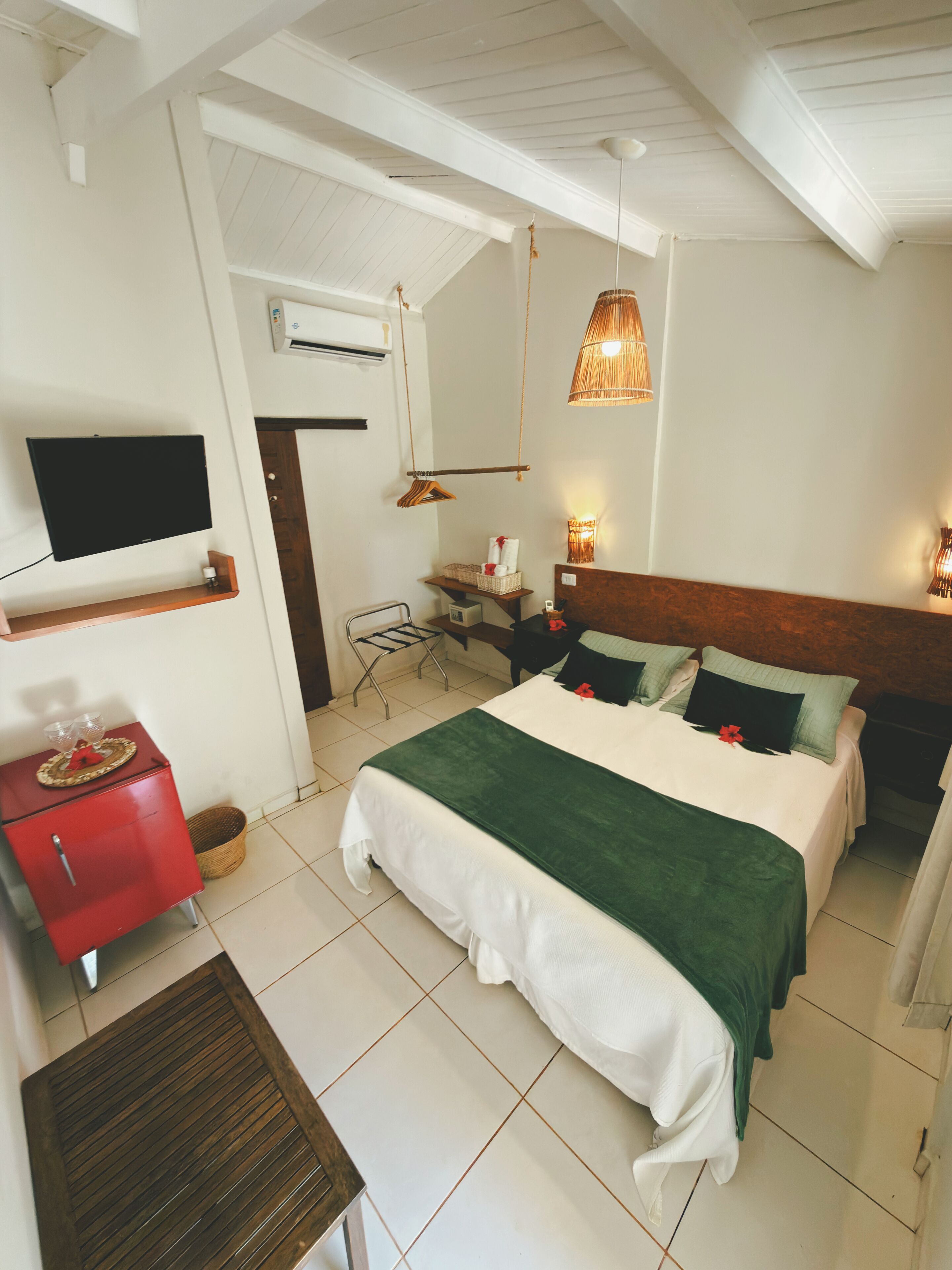 A hotel room with a bed, a TV, a desk, and a chair.