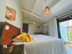 Une chambre à coucher avec un lit, une table de chevet, une lampe fixée au mur et une fenêtre donnant sur un beau paysage.