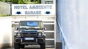 A black Mercedes-Benz G-Class SUV parked in front of a sign that reads "HOTEL AMBIENTE GARAGE". - Hotel Ambiente Berlin City (Berlin)