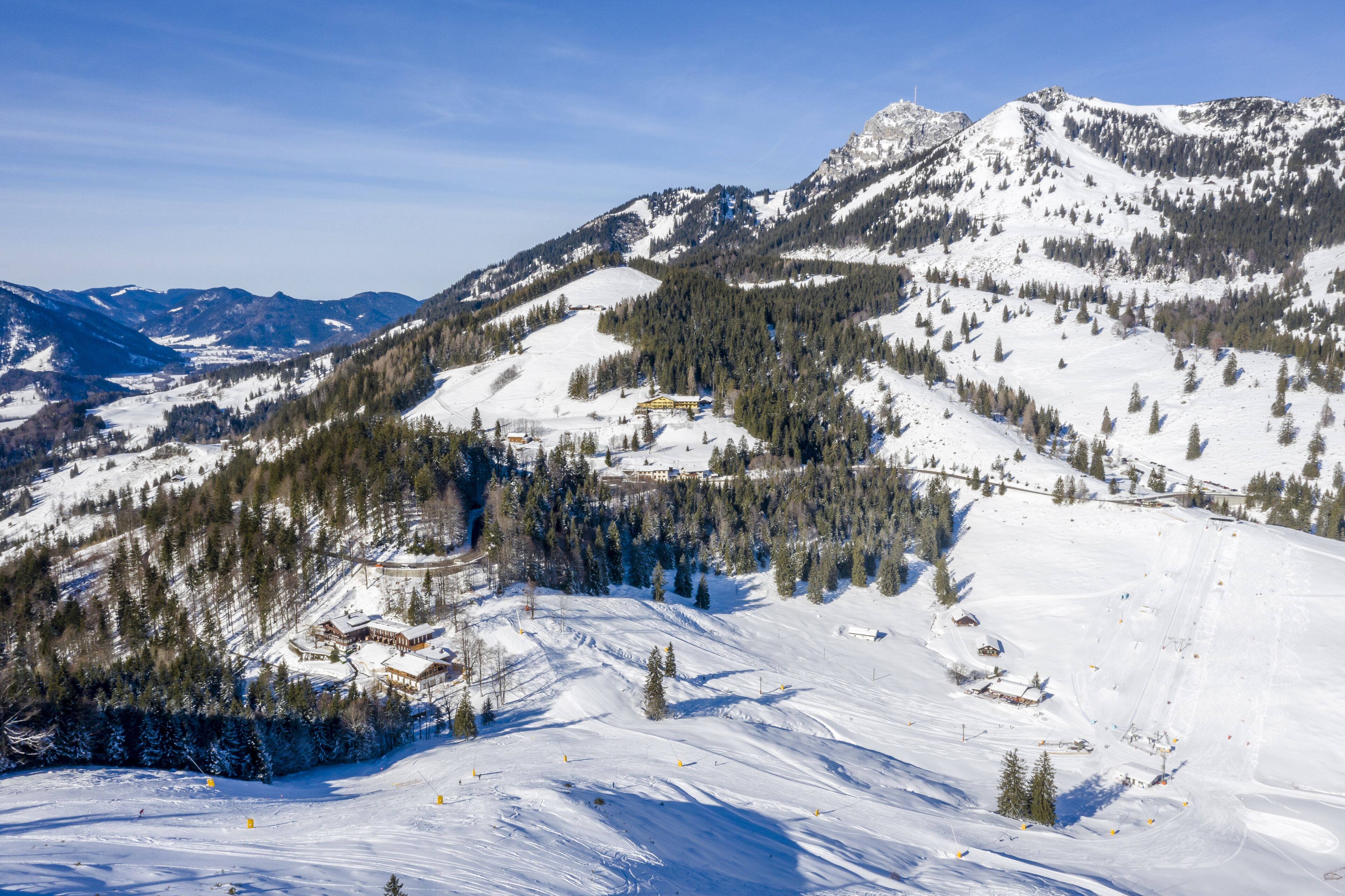 A snow-covered mountain landscape with a ski resort, including ski runs and a lodge.
