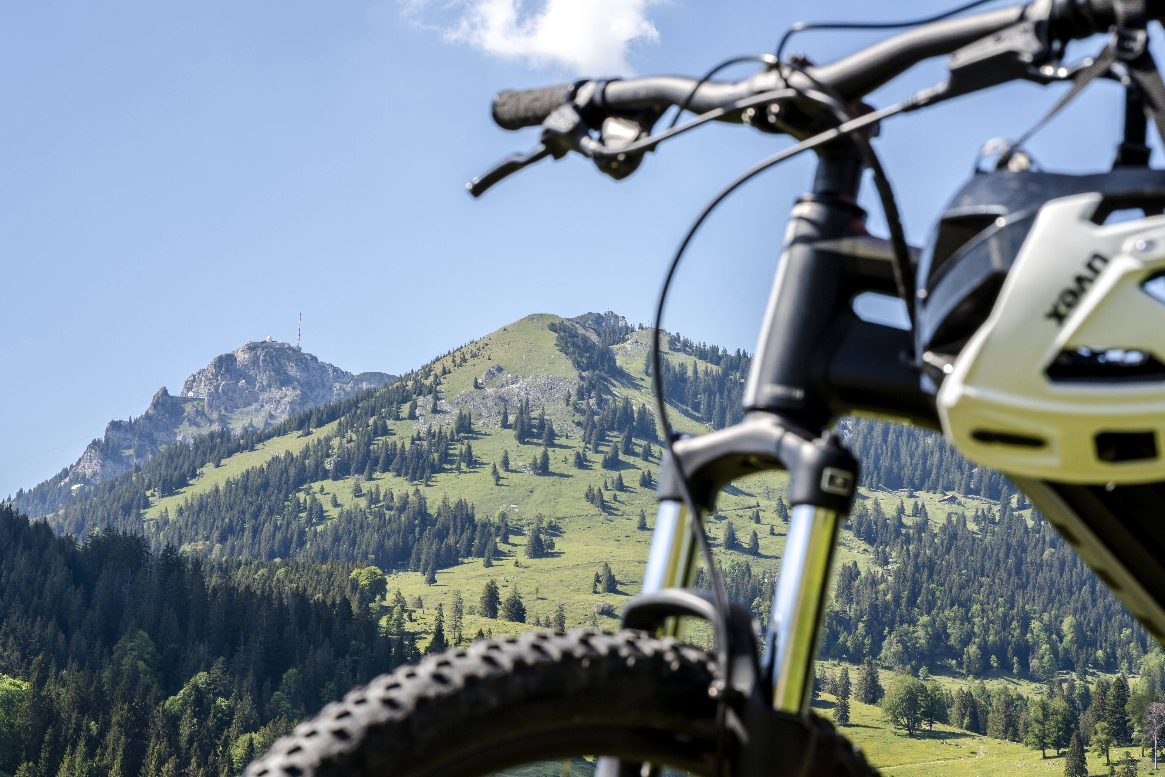 En mountainbike med udsigt over et grønt bjerglandskab.