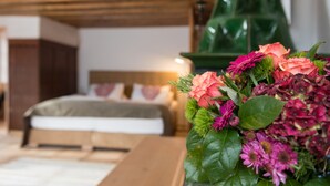 Un dormitorio con techo de madera, una cama con cabecera blanca y un adorno decorativo verde.