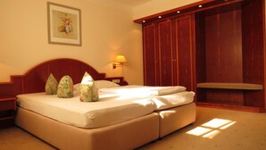 Une chambre d’hôtel avec un grand lit, une table de chevet, une lampe, une armoire et un tableau encadré au mur.