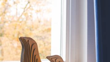 Two wooden bird-shaped sculptures on a windowsill.