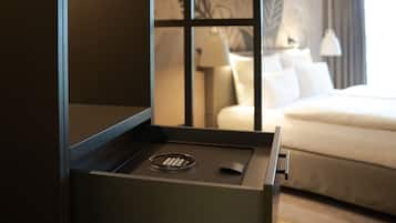 A hotel room with a bed, a nightstand, and a drawer with a remote control.
