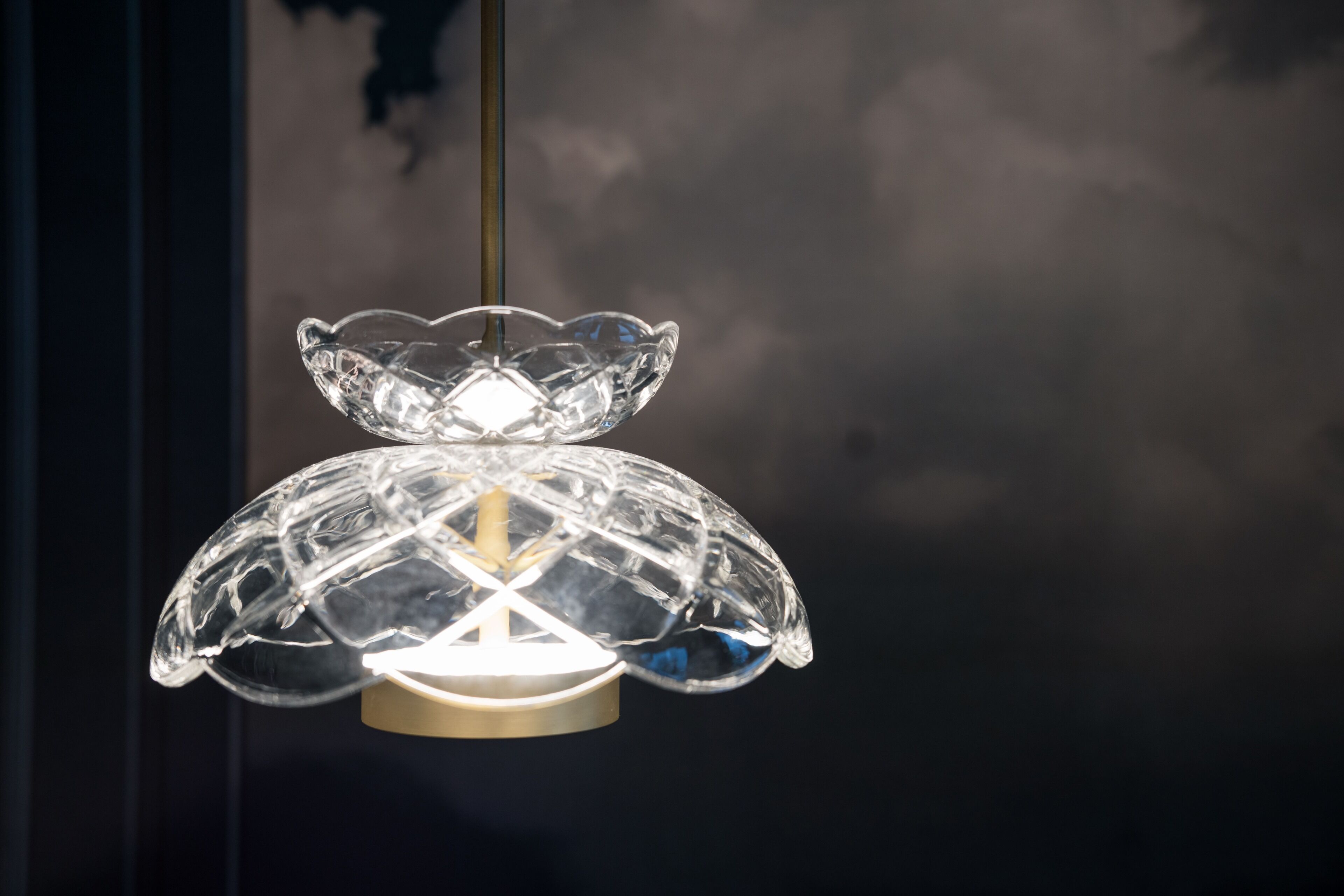 Eine klare Glaskugel-Pendelleuchte mit einer zentralen Glühbirne, die an der Decke hängt.