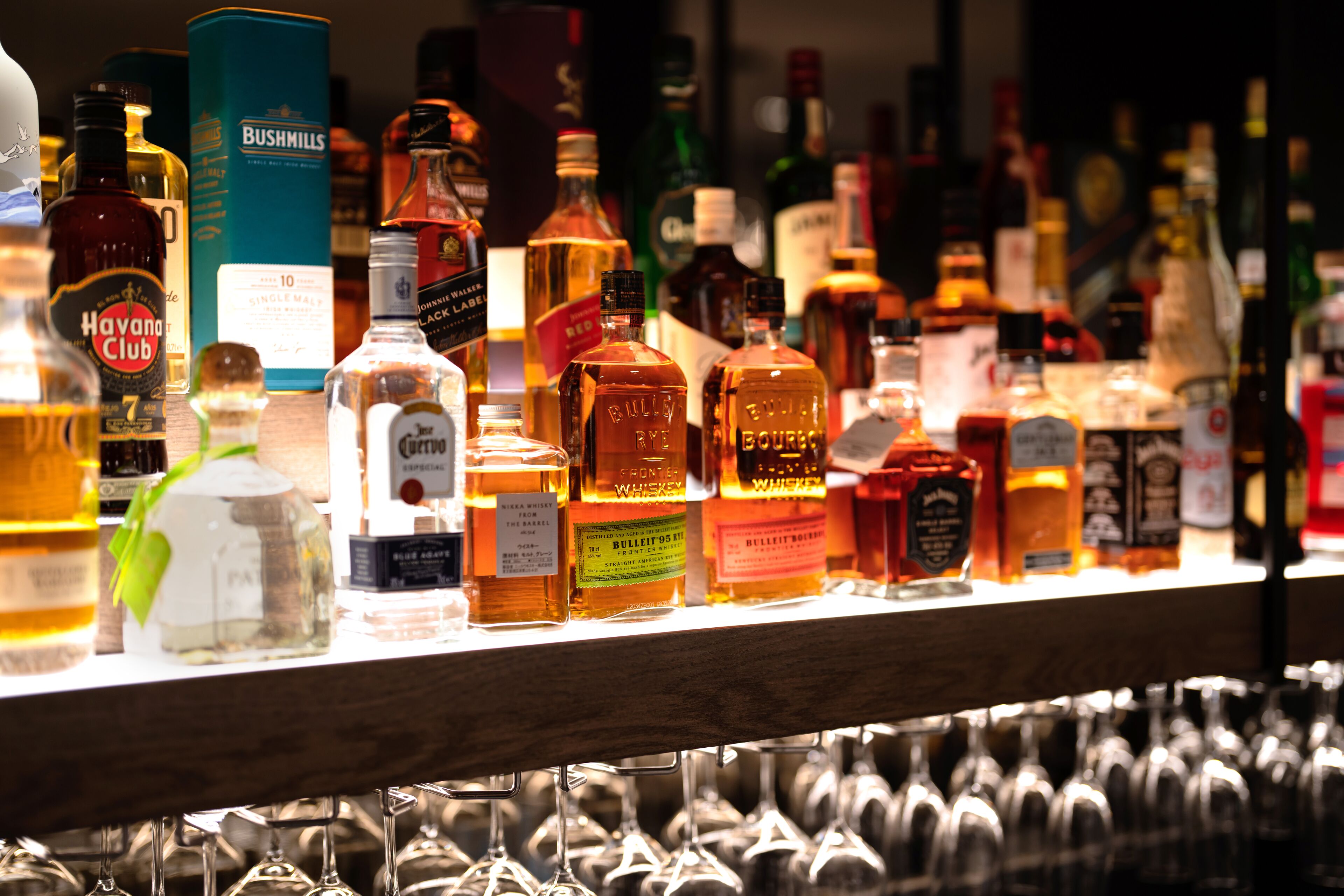 A bar with various liquor bottles and glasses.