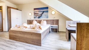 Une chambre moderne avec un lit en bois, un bureau et une vue sur la plage.