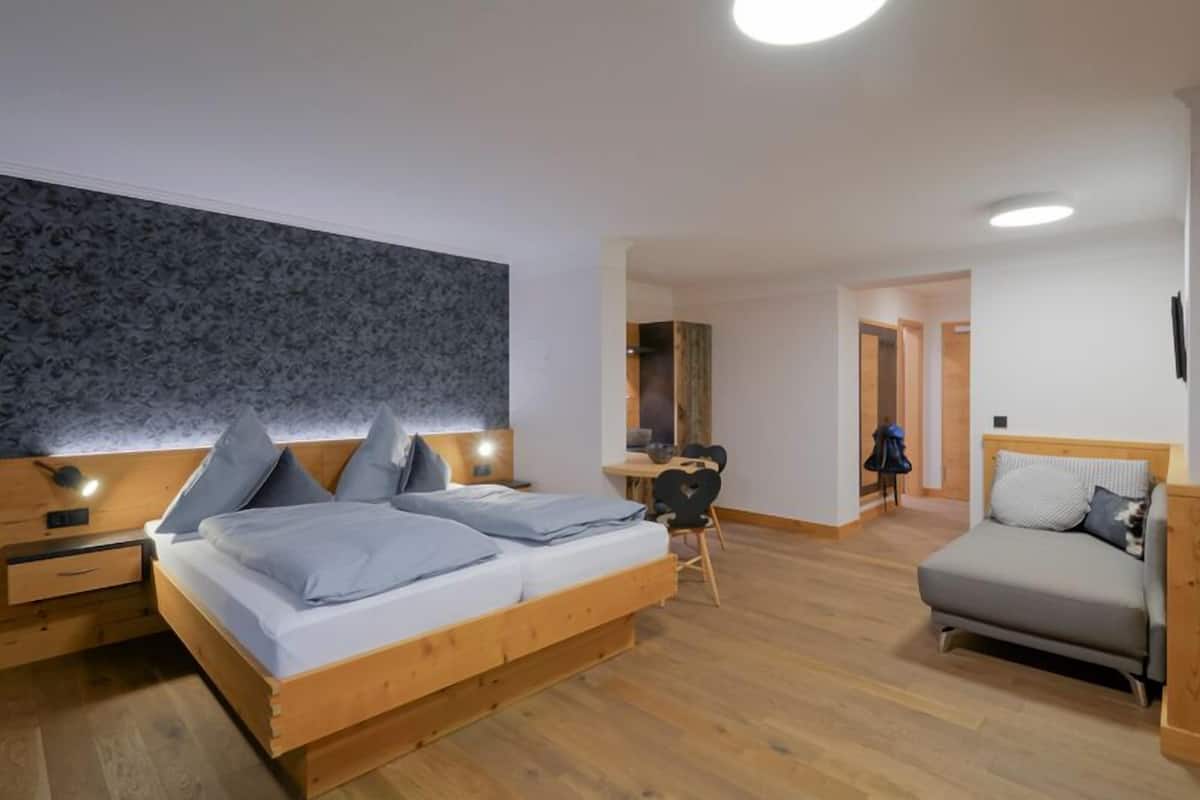 Un dormitorio moderno con una cama grande, un escritorio y un sofá.
