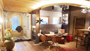 Un interior acogedor con piso de madera, un sofá, una mesa de comedor y una alfombra.