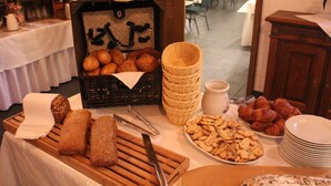 Montaje de bufé con panes, pasteles y una estación de café.