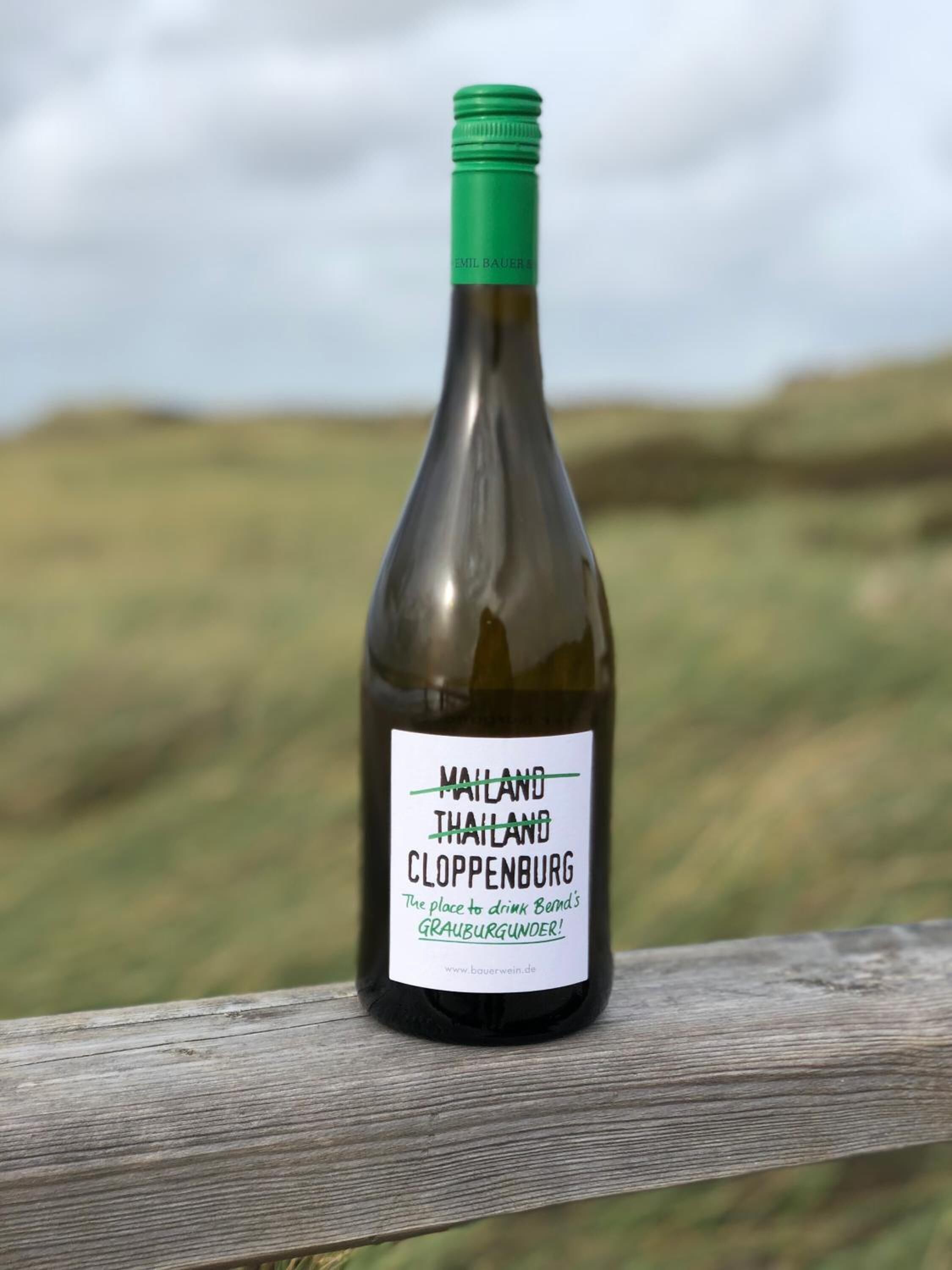 Una botella de vino con una etiqueta que dice "Nailand Thailand Cloppenburg" y una dirección web "www.bauerwein.de".