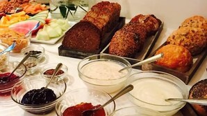 Ein Buffet mit verschiedenen Speisen, darunter Brot, Obst und Dips.