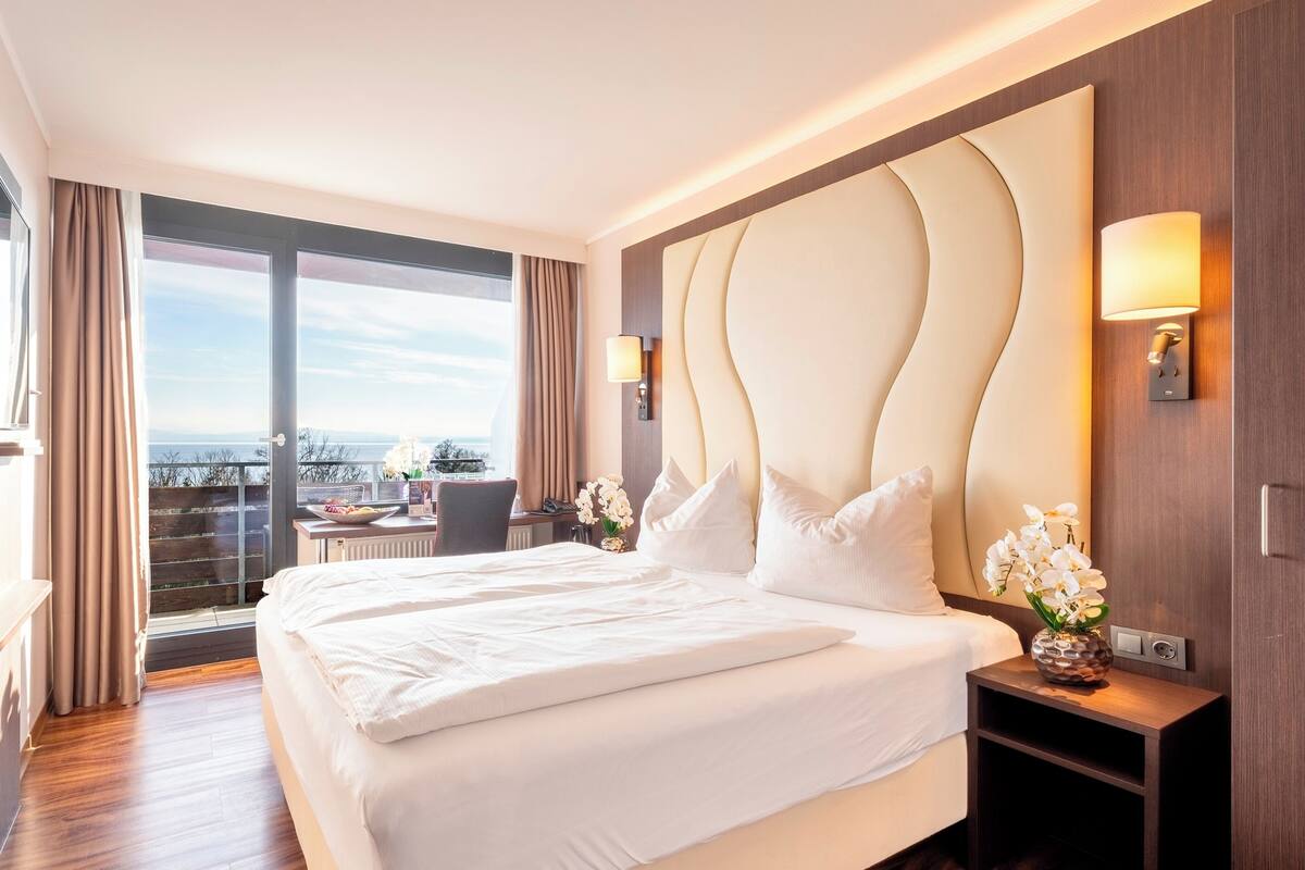 Une chambre d’hôtel avec un grand lit, un bureau, une télévision et une vue sur la ville.