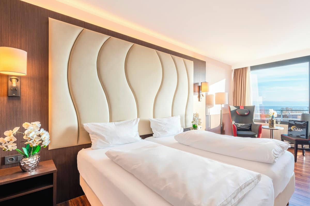 Une chambre d’hôtel avec un grand lit, un bureau, une chaise et une vue sur la ville.