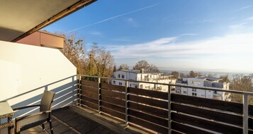 Uma varanda com vista para edifícios e árvores.