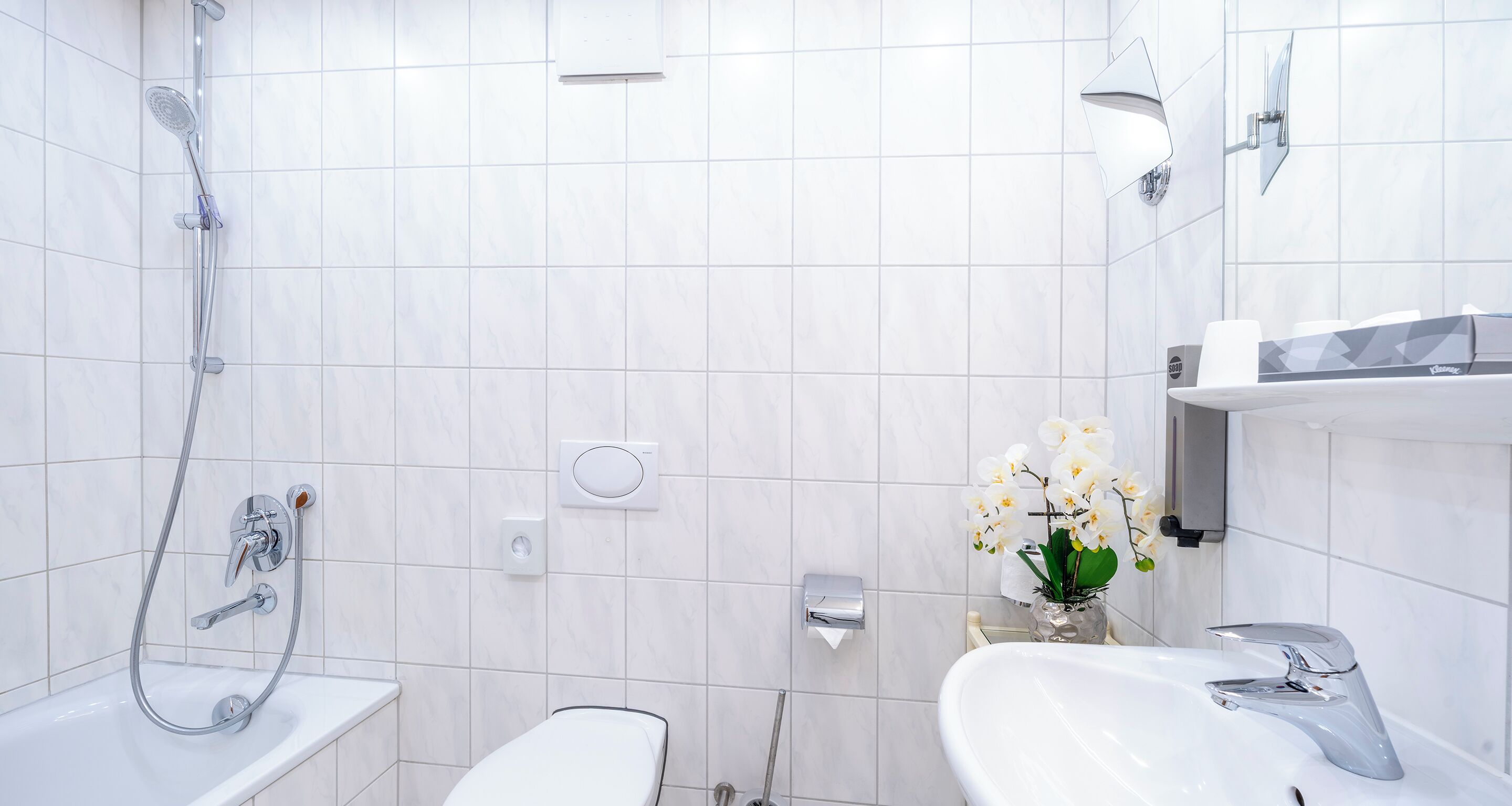 Une salle de bain moderne équipée d’une douche, de toilettes et d’un lavabo.