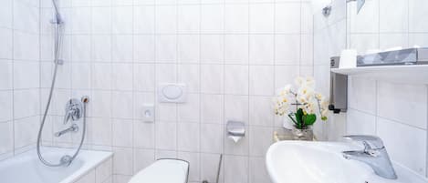 A modern bathroom with a shower, toilet, and sink.
