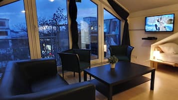 Habitació quàdruple Deluxe, 1 dormitori, no fumadors, zona enjardinada | Sala d'estar | Televisor intel·ligent de 32 polzades amb canals per satèl·lit