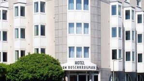 A hotel with a modern facade, multiple windows, and a sign reading "HOTEL AM BUSCHKRUGPARK". - Hotel am Buschkrugpark (Berlin)