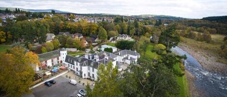 Un quartier résidentiel comprenant un grand ensemble immobilier, un parking et une rivière.