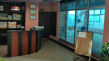 A reception area with a counter, a large window with a view, and a sign that reads "SAREM GYM".