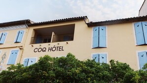 A building with the sign "COQ HOTEL" and blue shutters on the windows. - Coq Hôtel (Cogolin)