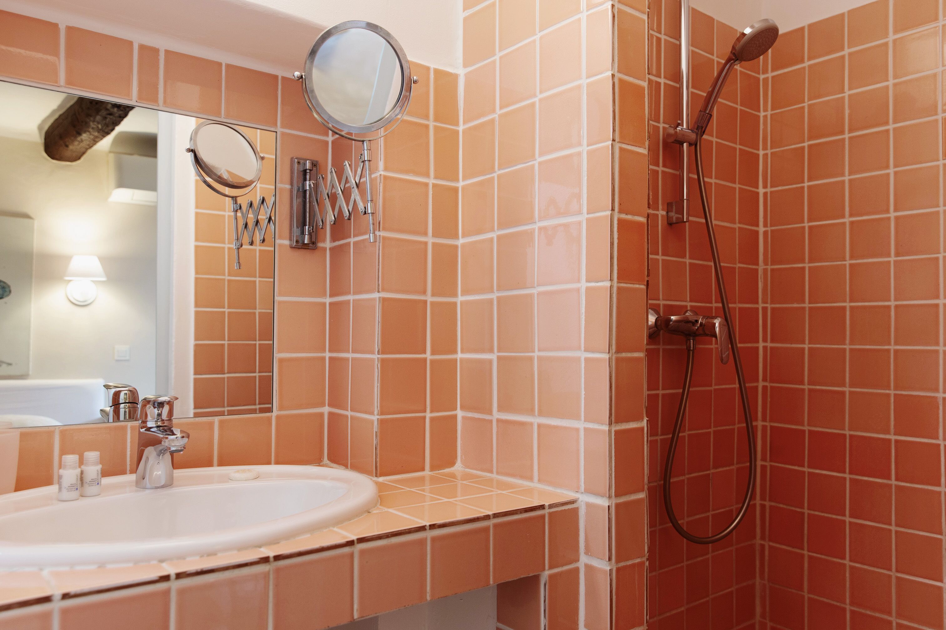 Un baño con lavamanos, espejo y ducha.