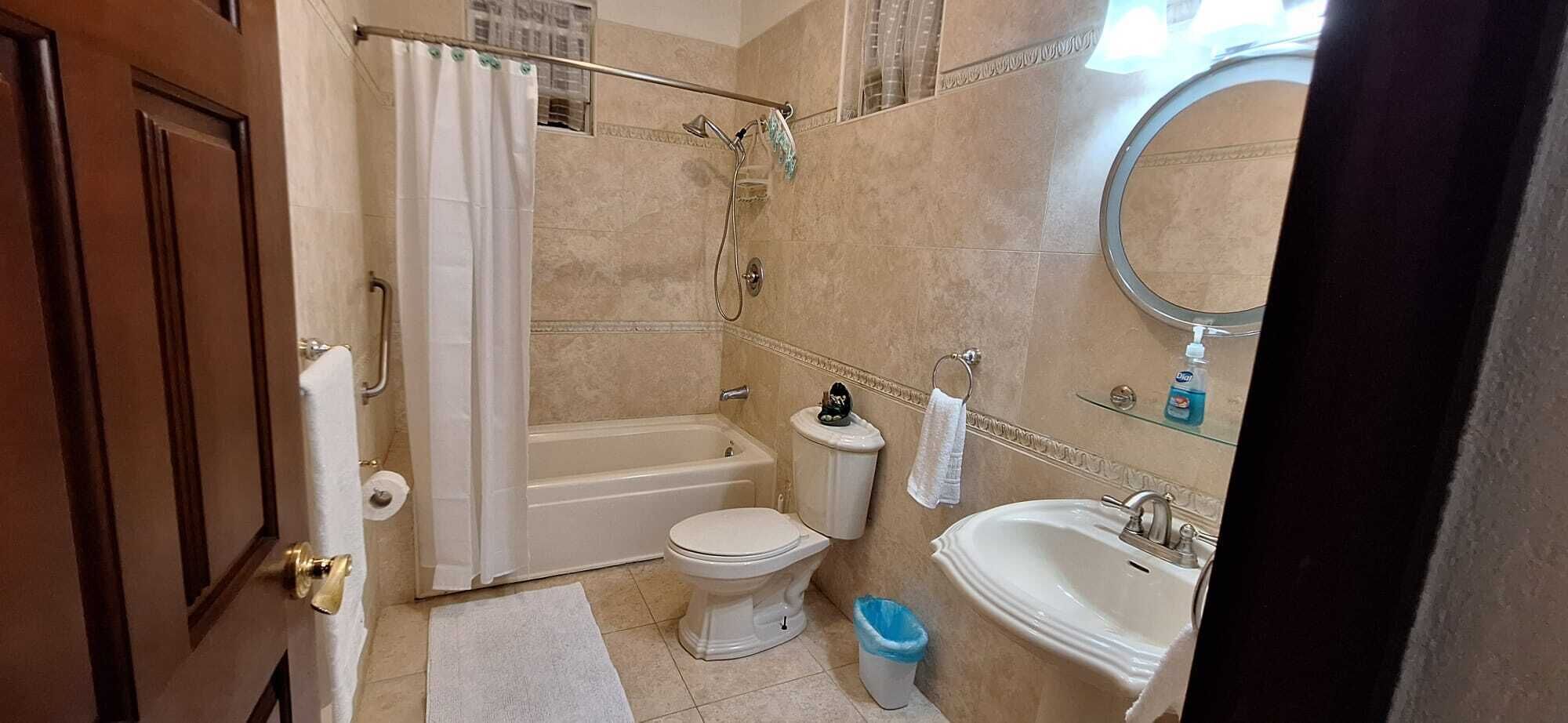 A bathroom with a bathtub, toilet, sink, and shower.