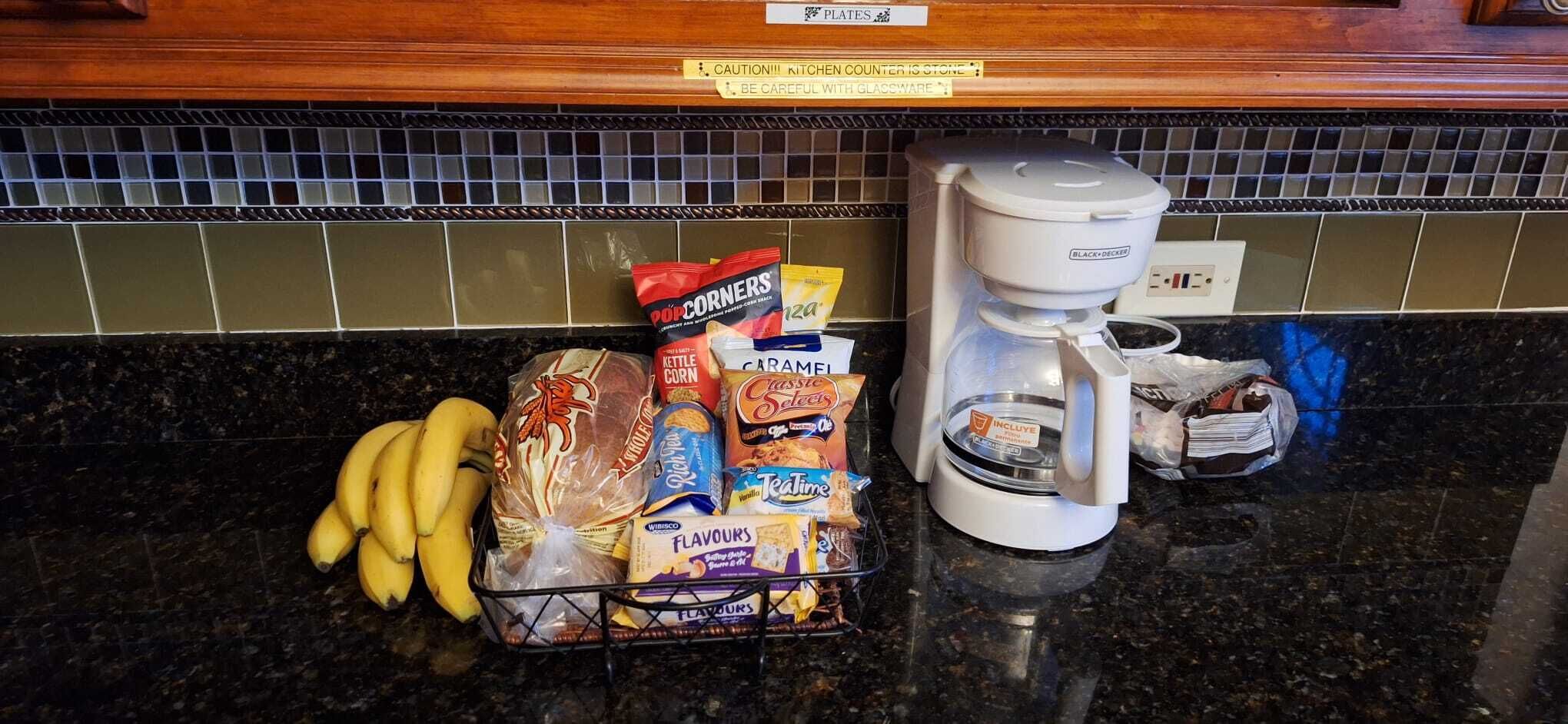 Eine Küchenarbeitsplatte mit einer Kaffeemaschine, einer Snack-Korb und einem Brotbeutel.