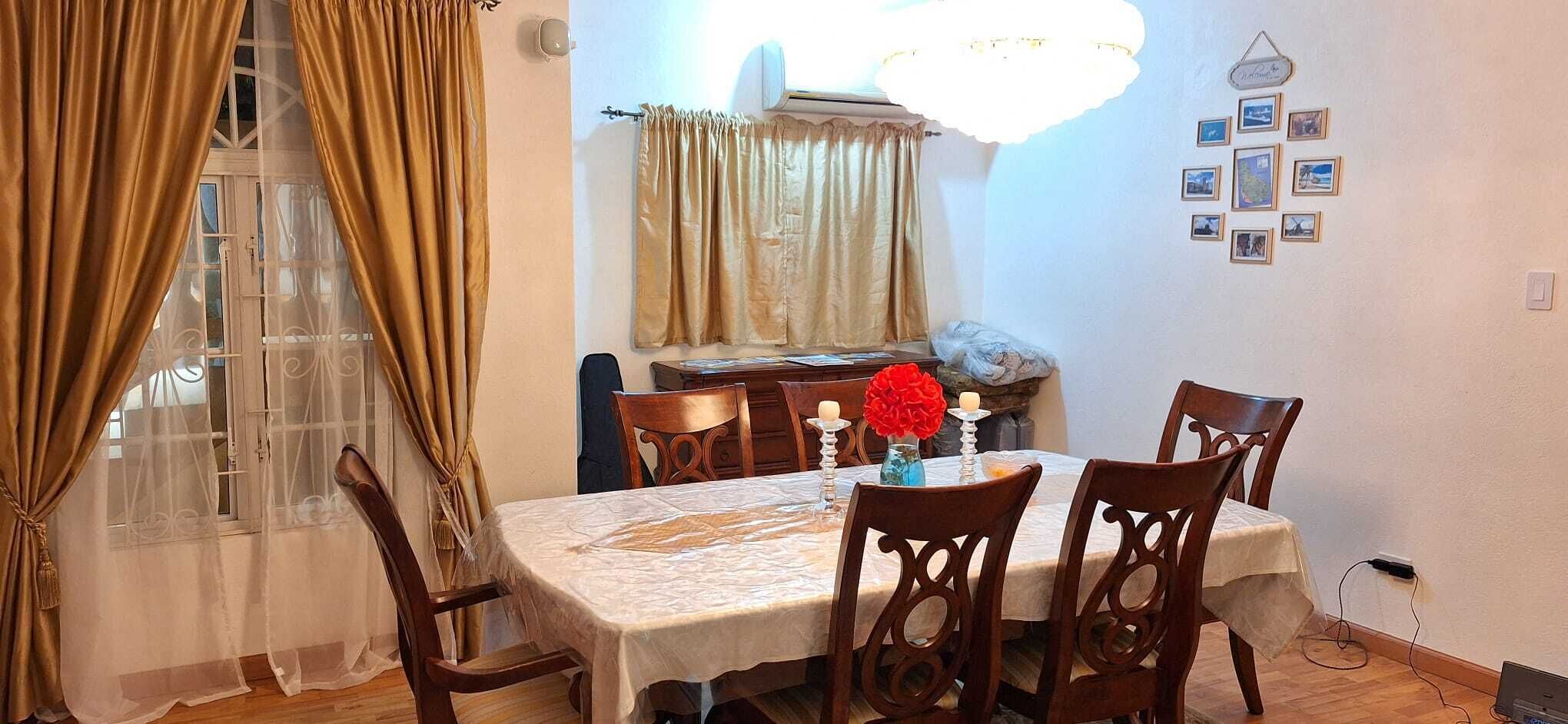 A dining area with a table set for four, surrounded by wooden chairs.