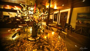 A dining area with a round table covered in bottle caps, a potted plant, and wooden chairs. - Beco Pousada Boutique Noronha (Fernando de Noronha)