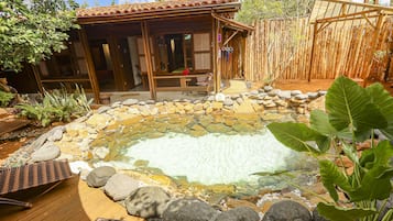Una piscina techada, sombrillas, sillones reclinables de piscina