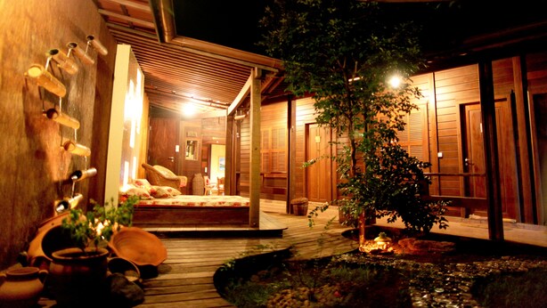 A traditional Japanese-style room with tatami flooring, a low wooden table, and a small garden area with a pond. - Beco Pousada Boutique Noronha (Fernando de Noronha)