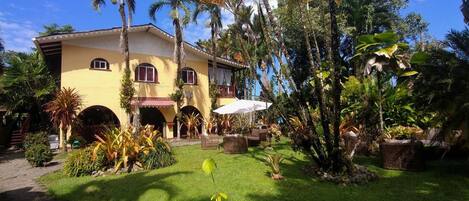 A yellow building with arched doorways and a covered patio area.