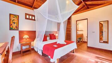 A bedroom with a four-poster bed, wooden headboard, and a red bedspread.