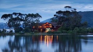 A lodge with a wooden exterior, a balcony, and a sign indicating it is a B&B.
