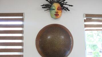 A room with a decorative mask and a textured bowl on the wall.