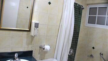 Un baño con lavamanos, inodoro, ducha y un espejo con marco dorado.
