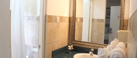 Un baño con inodoro, lavamanos y espejo.